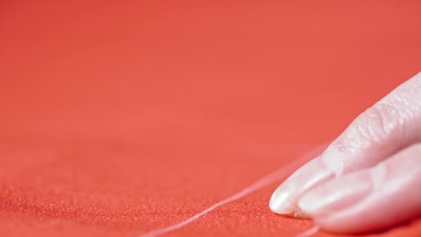 テーラーズフィンガーはピンを赤い生地に入れています 白いラインとピンで動作するドレスメーカーと赤い布 接近中だ コンセプト縫製と手芸 — ストック動画