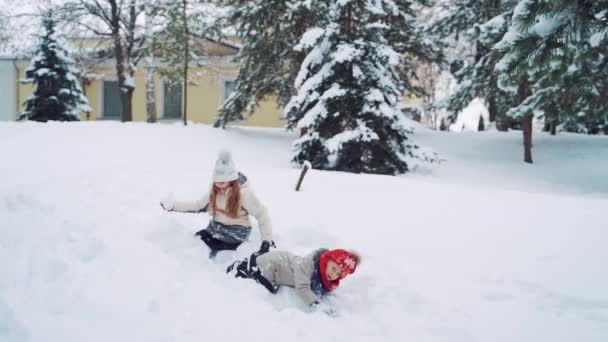 Dos Niñas Gateando Nieve Sobre Fondo Del Bosque Invierno Los — Vídeo de stock