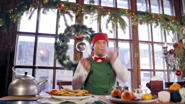 Ельф Грає Тангаринах Столом Ельф Сантас Сидить Різдвяним Столом Прикрашеній — стокове відео