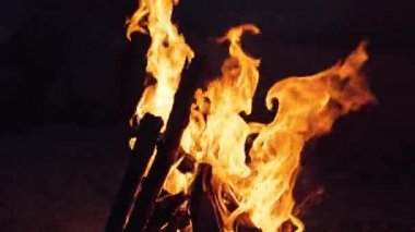 Şenlik ateşi. Turuncu alevlerde odun yakmak. Güzel ateş parlak bir şekilde yanar. Yavaş çekim