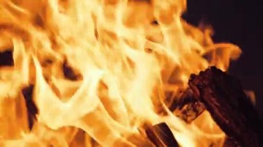 Şenlik ateşi geceleri yanıyor. Ağır çekimde siyah arkaplanda ateş alevleri.