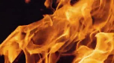 Şenlik ateşi geceleri yanıyor. Ağır çekimde siyah arkaplanda ateş alevleri.