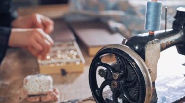 İş yerindeki terzinin el yapımı dikiş makinesi masanın arka planında. Eski siyah dikiş makinesi ve atölyenin yakınında bir terzi. Retro dikiş makinesi.