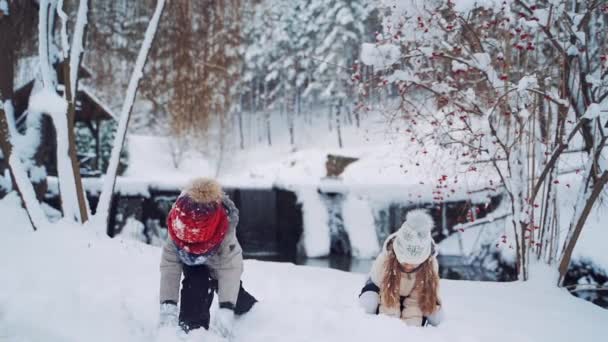 Gelukkige Kinderen Met Warme Jassen Caps Gooien Sneeuw Besneeuwde Achtergrond — Stockvideo