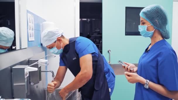 Cirujanos Uniforme Médico Máscaras Sus Rostros Lavándose Las Manos Hospital — Vídeo de stock