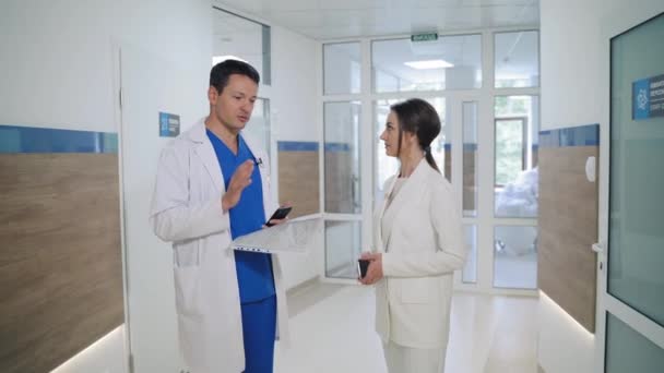 Mitarbeiter Weißen Arztkitteln Unterhalten Sich Vor Dem Hintergrund Einer Privatklinik — Stockvideo