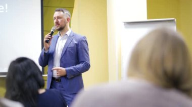 İş konferans odasında halka açık sunumları olan genç bir iş adamı. Konferans salonundaki izleyiciler. Girişimcilik Kulübü