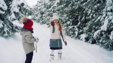Çocuklar karda dışarıda oynarlar. Aile Noel tatili için açık hava eğlencesi.