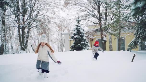 子供たちは冬に追いつく クリスマス休暇 クリスマスの日に美しい雪の冬の公園で子供のゲーム — ストック動画