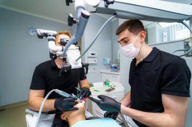 Modern dişçilik bürosu içi sandalye ve aletlerle dolu. Stomatolojide mikroskop.