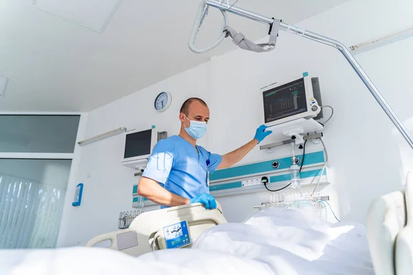 Modern medical bed and a special device in the modern ward. Doctor preparing equipment for the patient.