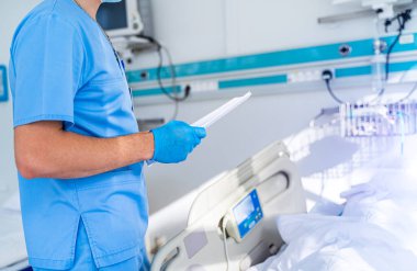 Modern tıp yatağı ve modern koğuşta özel bir cihaz. Reanimasyon odası. Doktor hasta için ekipman hazırlıyor.