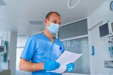 Maskeli doktor. Hastanedeki özel modern oda. Modern tıp yatağı ve modern koğuşta özel bir cihaz..