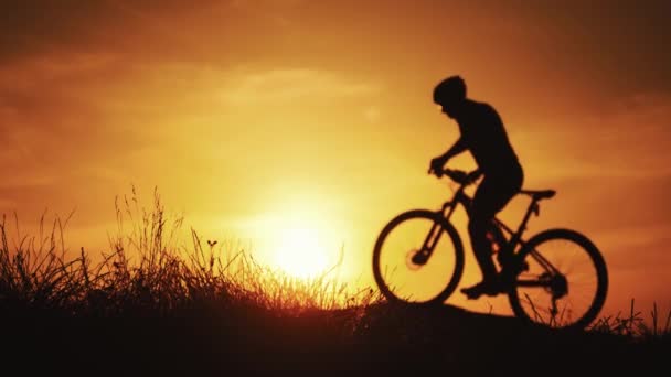 Silueta de un ciclista deportivo en casco en bicicleta. Concepto de estilo de vida activo. — Vídeos de Stock