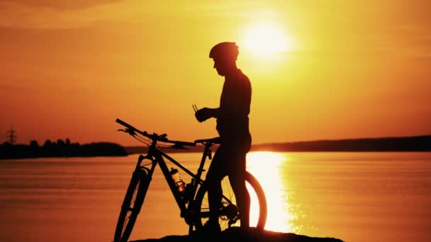 Silhueta de um ciclista esportivo no capacete em uma bicicleta. Conceito de Estilo de Vida Ativo. — Vídeo de Stock