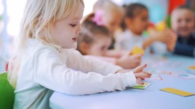 İlkokulda resimlerle oynarken İngilizce okuyan küçük çocuklar..