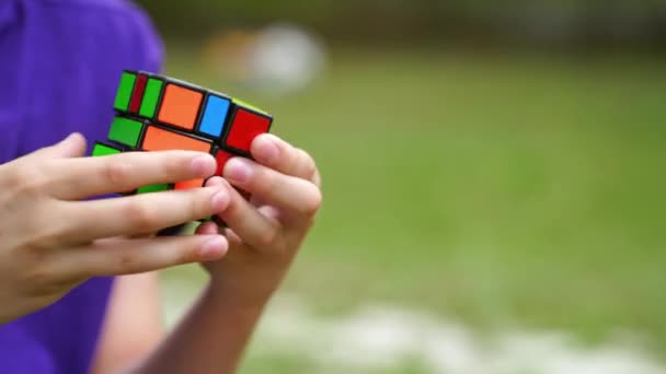 Boy practices with difficult Rubiks Cube. Concept of problem solving, solution, focus and goal