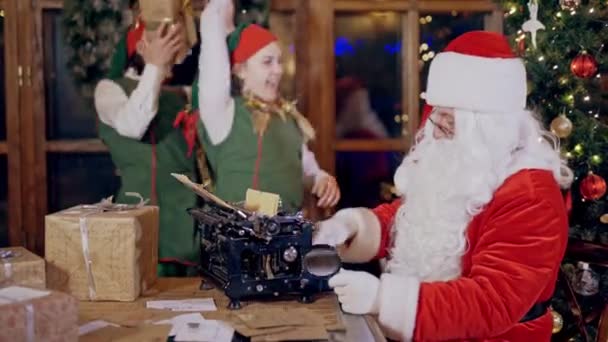 サンタとエルフクリスマスの装飾室内でプレゼント — ストック動画