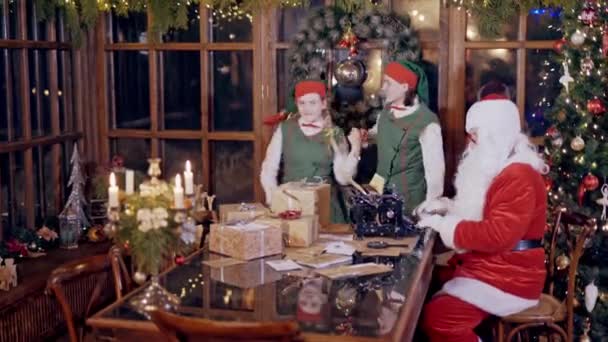 Moș Crăciun Este Ocupat Mașina Scris Timp Doi Elfi Dansează — Videoclip de stoc