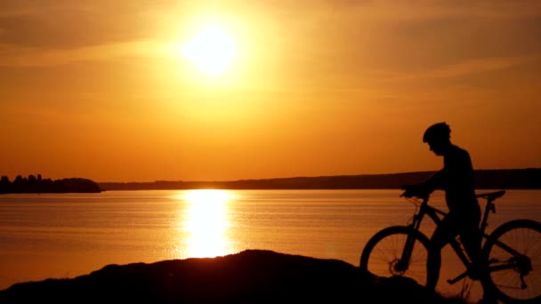 Silhueta Ciclista Masculino Com Capacete Pôr Sol Perto Rio Motociclista — Vídeo de Stock