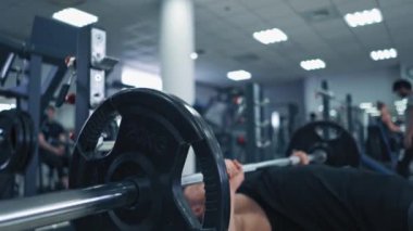 Antrenman sırasında ağır halterleri adamın eline yakın çekim. Kas sporcusu spor kulübünde kol kaslarını geliştirmek için halteri kaldırıyor..