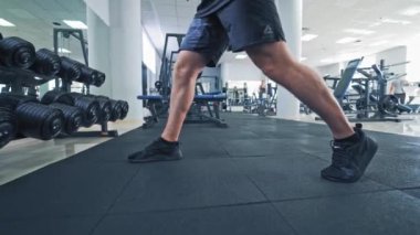Güçlü erkek ve kadın spor salonunda dambıllarla oturuyorlar. Modern spor salonlarında halterlerle egzersiz yapan sağlıklı bir çift..