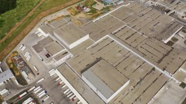 Endüstriyel fabrikanın gri çatısından bakın. Kamyon park yeri olan bir üretim tesisi. Hava görünümü.