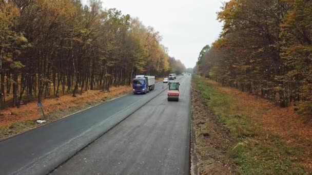 汽车在沥青路面上行驶 公路的一侧在森林中的公路上修路 相机移回 — 图库视频影像