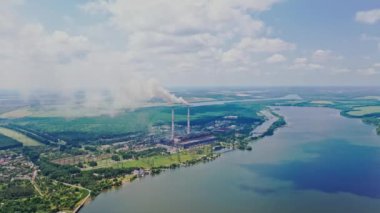Büyük bir fabrika ile kırsal kesimde kötü bir çevre. Borulardan çevreye zararlı emisyonlar. Doğal manzara ve metalurji bitkisi. Hava görünümü.