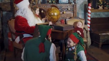 Mutlu elfler, Noel Baba ve çocuklar mutlu vakit geçiriyorlar. Noel Baba 'nın evinin Noel atmosferinde peri kahramanları ve Noel Baba.