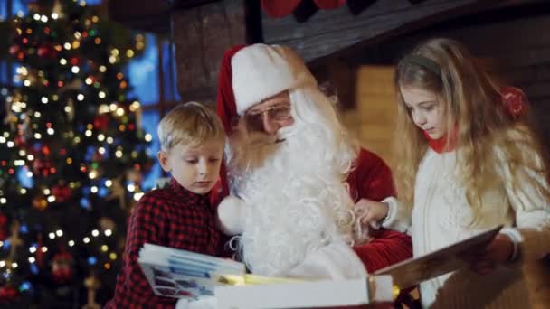 Małe Dzieci Mikołajem Przyglądające Się Interesującemu Albumowi Święty Mikołaj Tradycyjnym — Wideo stockowe
