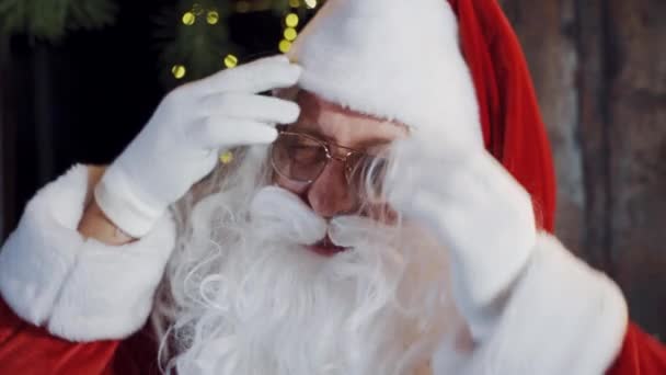 戴眼镜 留着白胡子的圣诞老人 房子里穿着白色和红色服装戴着眼镜的圣诞老人的画像 — 图库视频影像