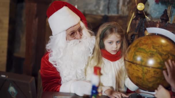 Санта Клаус Красива Дівчина Дивляться Круглий Глобус Приміщенні Дитячі Руки — стокове відео
