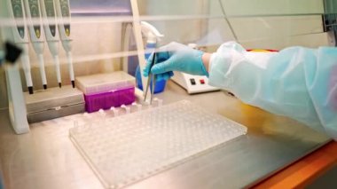 Laboratuvarda kan örneği toplamak için vakum tüpleri. Araştırma laboratuarında elinde kan tüpü testi tutan teknisyen.