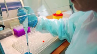 Laboratuvarda kan örneği toplamak için vakum tüpleri. Araştırma laboratuarında elinde kan tüpü testi tutan teknisyen.