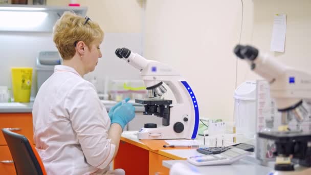 Βοηθός Εργαστηρίου Μικροσκόπιο Στο Ιατρικό Κέντρο Γυναίκα Επιστήμονας Που Κάνει — Αρχείο Βίντεο