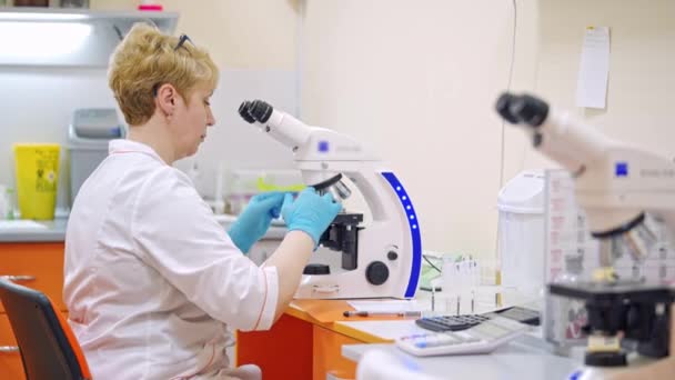 Laboratorieassistent Med Mikroskop Medicinsk Center Kvindelig Videnskabsmand Gør Research Med – Stock-video