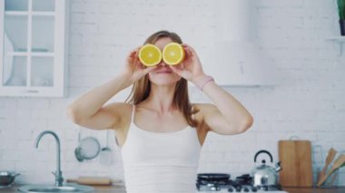 Genç bir kadın evde yemek yaparken mutfakta eğleniyor.