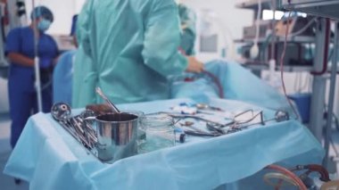Ameliyathanede steril bir masada tıbbi aletler. Çalışma sürecinin arka planında tıbbi araçlara sahip küçük tablo.