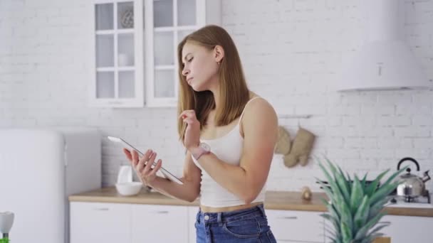 Evde Yemek Pişirirken Tarifini Tabletten Kontrol Eden Genç Bir Kadın — Stok video