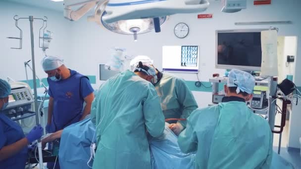 Αρκετοί Γιατροί Θεραπεύουν Τον Ασθενή Στο Σύγχρονο Χειρουργείο Τρεις Επαγγελματίες — Αρχείο Βίντεο