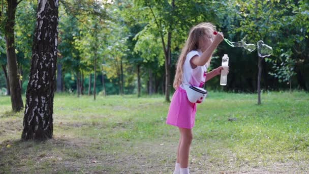 Cute Little Girl Różowym Garniturze Długimi Włosami Dmuchanie Baniek Mydlanych — Wideo stockowe