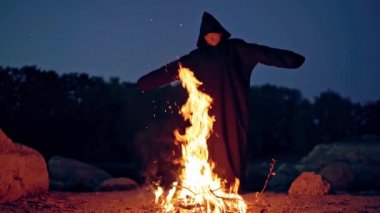 Ateş yakma ayini sırasında mantoda siyah cadı, Cadılar Bayramı konsepti