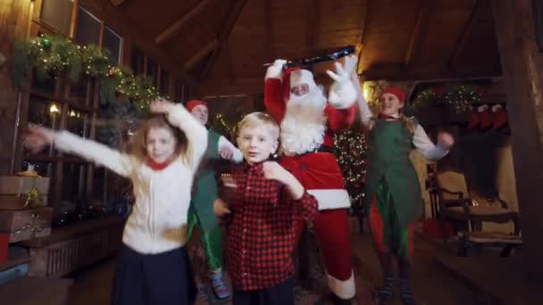 圣诞节时 圣诞老人和吉他 精灵和孩子们快乐地共舞在一起 在装饰过的房子里欢庆圣诞 — 图库视频影像