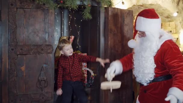 圣诞老人给了一个小男孩自制的玩具飞机 给孩子们的圣诞礼物 可爱的男孩在屋里收到圣诞老人送来的木制玩具 — 图库视频影像