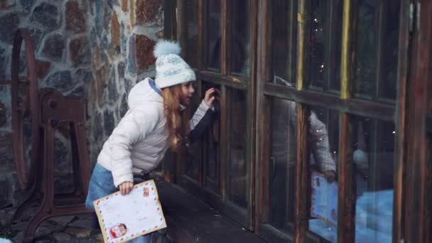 Маленькая Девочка Смотрит Через Маленькие Деревянные Окна Улице Любопытный Ребенок — стоковое видео