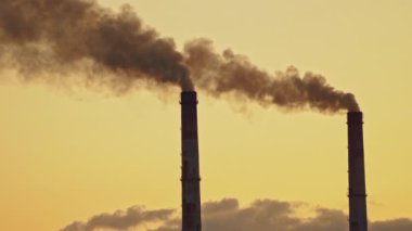 Hava kirliliği. Metalurji bitkisinin borularından çıkan gri duman. Endüstriyel borulardan çevreyi dolduran zehirli emisyonlar yaşamı kötü etkiliyor. Ekolojik felaket.