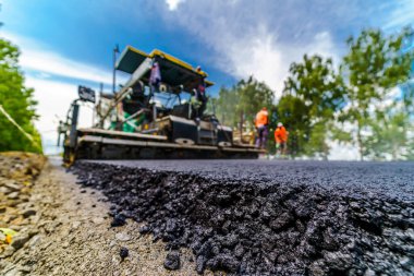 Yeni yol inşaatında çalışan yol makinelerinin geniş görünümü.