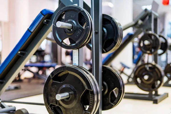 Pancakes on a dumbbell in a gym. Sport and healthy life concept. Set of pancakes on gym background. Sport equipment closeup.