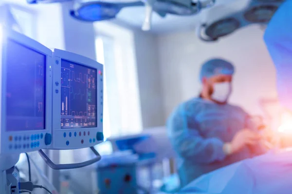Medician performing surgical operation in bright modern surgery room. Operating theatre. Modern equipment in clinic. Emergency room. Blurred background.